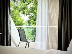 a chair sitting on a balcony looking out a window at Rest Bugis Hotel in Singapore