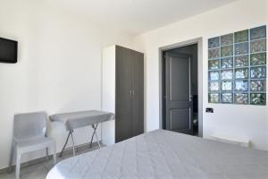 1 dormitorio con 1 cama, 1 silla y 1 ventana en Casa Ami, en Arzana