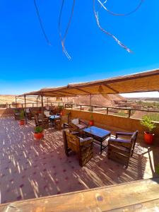 a patio with tables and benches on a roof at Kasbah El Hajja in Aït Benhaddou