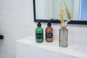 two bottles and a vase on a shelf in a bathroom at ImmoStay Stuhr - 2 Apartments mit Balkon, Wifi & Homeoffice in Stuhr