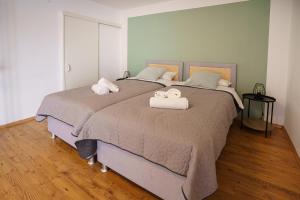 a bedroom with a large bed with towels on it at ImmoStay Stuhr - 2 Apartments mit Balkon, Wifi & Homeoffice in Stuhr