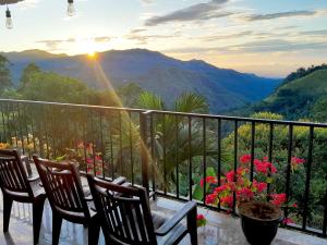 a balcony with chairs and a table with a view of mountains at Golden View Guest in Ella
