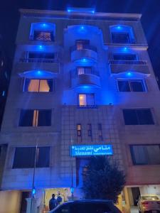 アル・コバールにあるمنامي للشقق المخدومة-كورنيش الخبر-اقتصاديの青いライトが映える建物