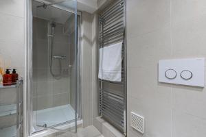 a bathroom with a shower with a glass door at Grosvenor Mayfair in London