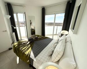 a bedroom with a bed and a large window at Banana Cake - piscina, doble terraza, última planta , wifi y parking in Corralejo