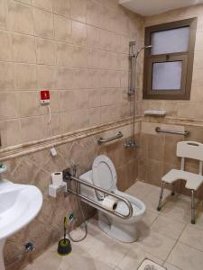 a bathroom with a toilet and a sink at منامي للشقق المخدومة-كورنيش الخبر-اقتصادي in Al Khobar