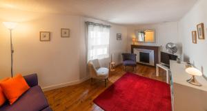 a living room with a couch and a red rug at Rue du Barri in Cordes-sur-Ciel