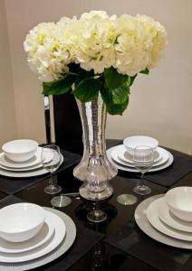 a vase filled with white flowers sitting on a table at Lovely 2-Bed Apartment in Stanford-le-Hope in Stanford-le-Hope