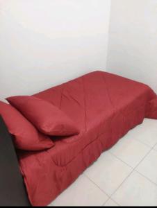 a red bed with two red pillows on it at 3 Bedroom Apartment with Pool and Beautiful View in Klebang, Ipoh in Chemor