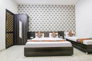 a bedroom with two beds and a wallpaper at FabHotel Ace in Ludhiana