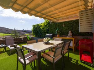 a table and chairs under an umbrella on a patio at Vista Golf 20 by VillaGranCanaria in Maspalomas