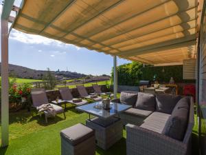a patio with a couch and tables and chairs at Vista Golf 20 by VillaGranCanaria in Maspalomas