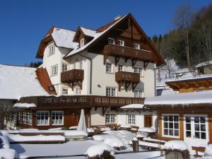 a large building with snow on the ground at Althammerhof in Klamm
