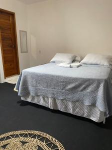 a bedroom with a bed with a white comforter at Jangadas do Pontal in Fortim