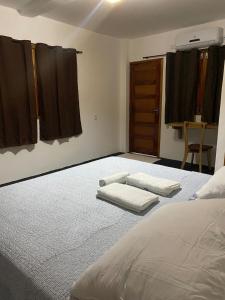 a bedroom with a bed and two towels on the floor at Jangadas do Pontal in Fortim