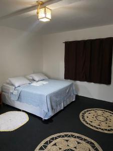 een slaapkamer met een bed en twee tapijten op de vloer bij Jangadas do Pontal in Fortim