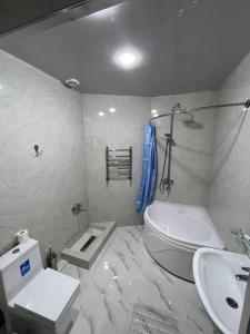 y baño con aseo blanco y lavamanos. en Sofiya Tashkent Hotel, en Tashkent