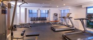 une salle de sport avec plusieurs tapis de course et appareils d'exercice dans l'établissement Alex apartment Horizon 101, à Cebu