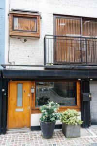 ein Gebäude mit einer Holztür und einem Balkon in der Unterkunft Remarkable 1-Bed House in London in London