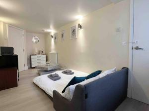 a bedroom with a bed with a blue couch at Remarkable 1-Bed House in London in London