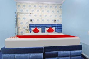 a blue bedroom with a bed with red pillows at OYO Flagship Meenu Inn in Jaipur