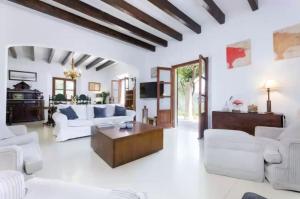 a living room with white furniture and a wooden ceiling at Puig de Garrafa in Andratx