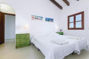 two beds in a white room with a green dresser at Puig de Garrafa in Andratx