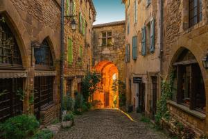 an alley in an old town with an archway at Rue du Barri in Cordes-sur-Ciel