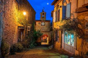 an alley with a clock tower on a building at Rue du Barri in Cordes-sur-Ciel