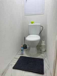 a bathroom with a toilet and a black rug at Apartmán Majka in Snina