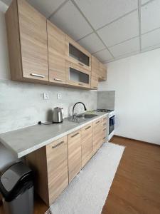una cocina con armarios de madera y fregadero en Apartmán Majka, en Snina