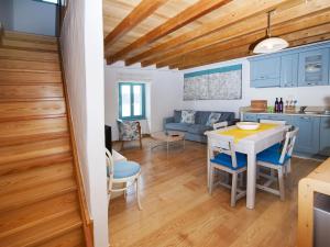 a kitchen and living room with blue cabinets and a table at Apartment Pastello in Rovinj