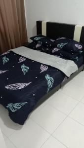 a bed with a blue comforter and pillows on it at 3 Bedroom Apartment with Pool and Beautiful View in Klebang, Ipoh in Chemor