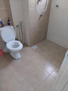 a bathroom with a white toilet and a shower at 3 Bedroom Apartment with Pool and Beautiful View in Klebang, Ipoh in Chemor