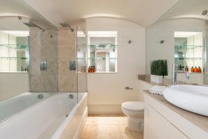 ein Badezimmer mit einer Badewanne, einem Waschbecken und einem WC in der Unterkunft Stay Mayfair in London