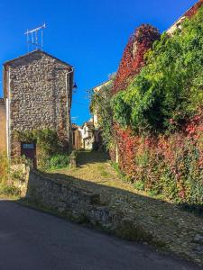 a stone wall next to a road next to a building at Rue du Barri in Cordes-sur-Ciel