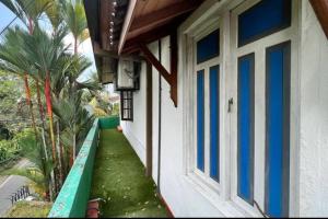 uma casa com uma porta azul e branca e palmeiras em Luxury Fully furnished house for 8 people ! em Sri Jayewardenepur- Kotte