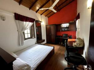 um quarto com uma cama, uma secretária e uma cadeira em Luxury Fully furnished house for 8 people ! em Sri Jayewardenepur- Kotte