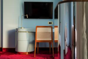 a room with a table and a chair and a television at Bazzar Boutique Hotel in Tbilisi City