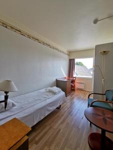 um quarto de hotel com uma cama e uma mesa em SKAP Hostel Mandal em Mandal