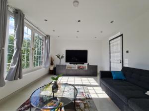 sala de estar con sofá y TV en Luxury Apartment Limehouse en Londres