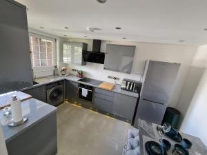 una cocina grande con electrodomésticos de acero inoxidable en una habitación en Luxury Apartment Limehouse en Londres