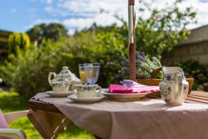 una mesa con tazas de té y platillos en ella en LOW COST CASA BRAIS en San Pedro de Benquerencia