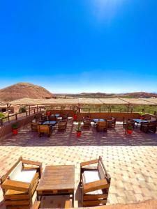 a patio with tables and chairs in the desert at Kasbah El Hajja in Aït Ben Haddou