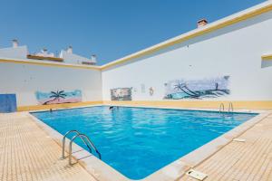 a large swimming pool with blue water in a building at Alfamar Apartment at Praia da Falesia in Albufeira
