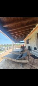 eine Terrasse mit einem Tisch und einem Holzdach in der Unterkunft Casa Vera in A Guarda