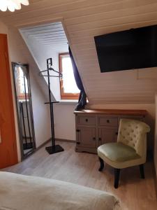 a bedroom with a bed and a tv and a chair at Ferienhaus Aschersleben in Aschersleben