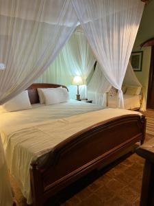 a bedroom with a large bed with white drapes at Charmoso bangalô balinês pé na areia Outeiro das Brisas in Praia do Espelho +33 photos
