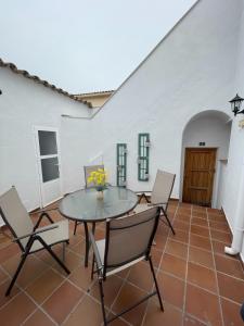 eine Terrasse mit einem Tisch und Stühlen auf einem Fliesenboden in der Unterkunft Casa rural 3R in Don Álvaro