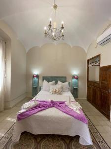 a large bedroom with a large bed and a chandelier at Casa rural 3R in Don Álvaro